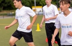 Eine Fußballmannschaft schwört sich vor dem Spiel in der Kabine ein, indem sie ihre Hände übereinander legen.